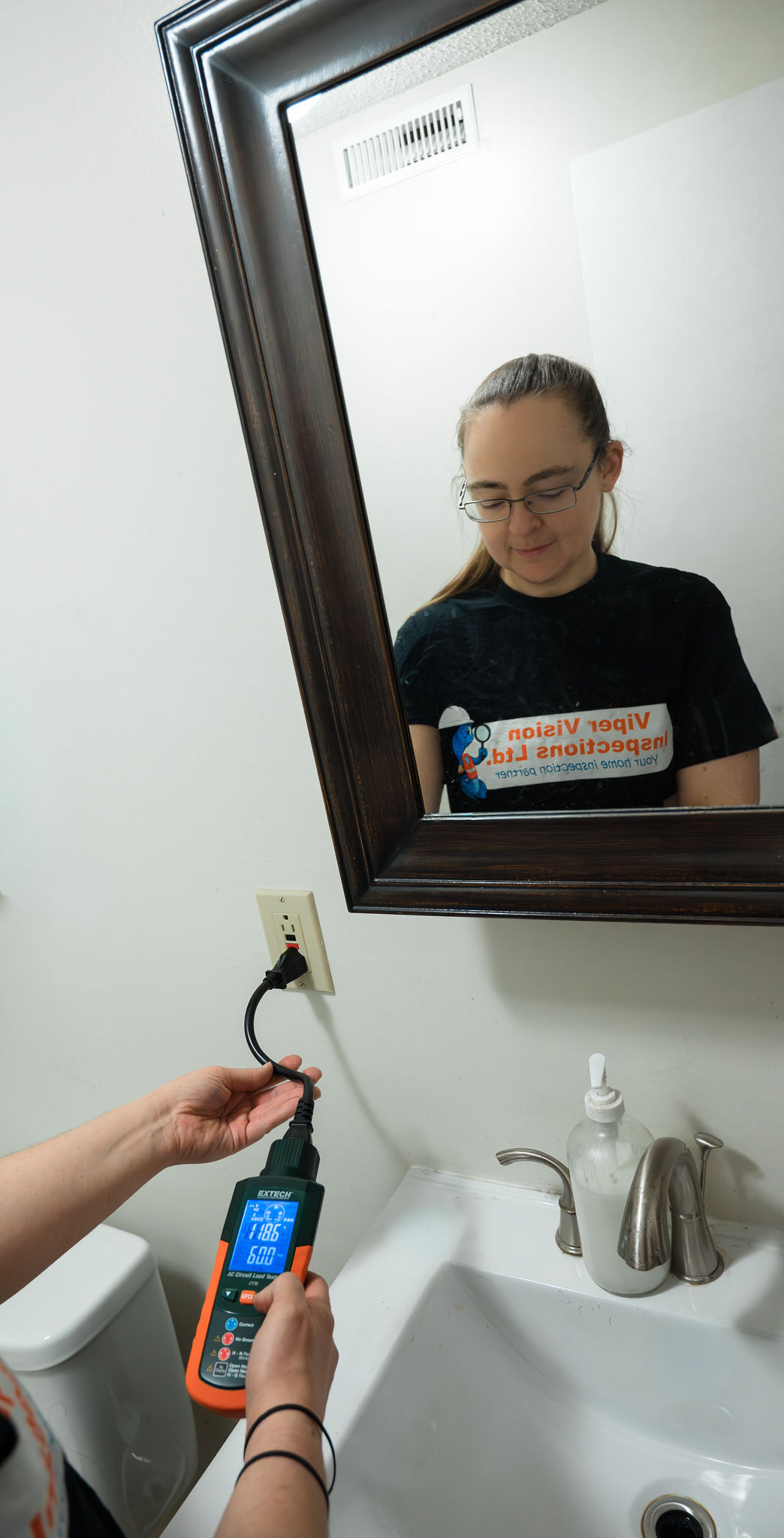 Home inspector checking outlet in bathroom, GFCI safety